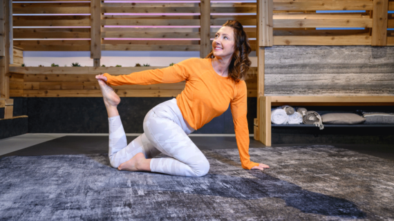 Cassy stretches on the ground, holding her foot behind her