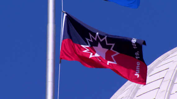 Red and black Juneteenth flag with a white starburst design and the text 