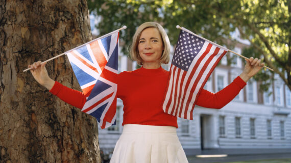Lucy Worsley holds up the British flag in one hand and the United States flag in the other.